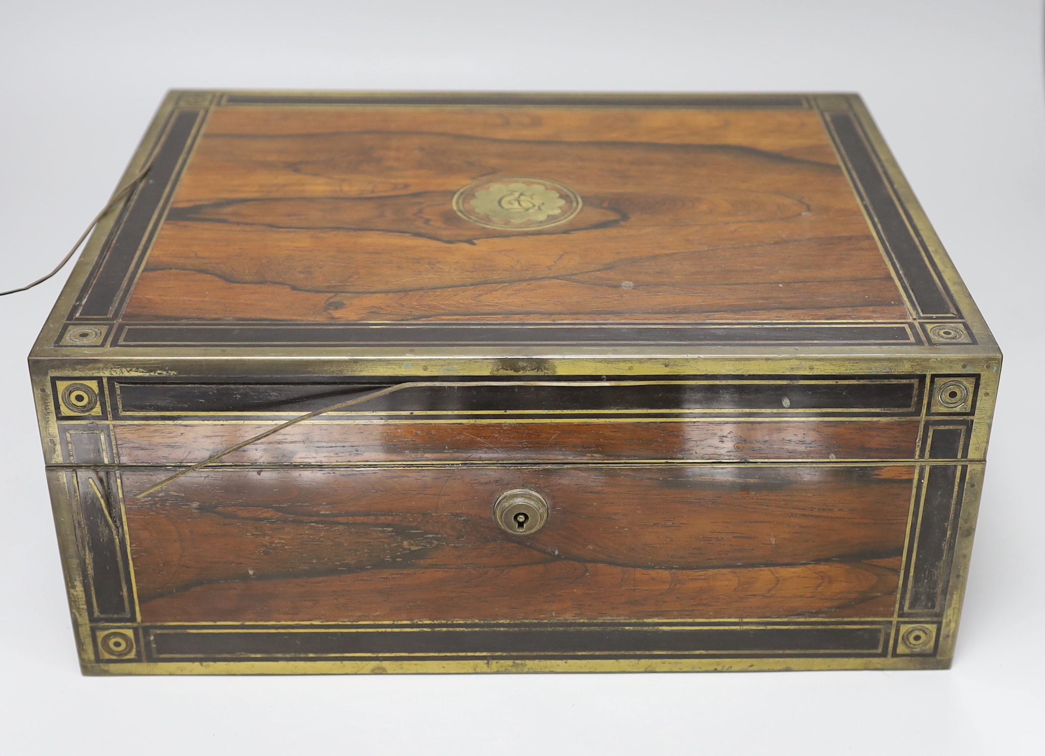 A George IV brass mounted rosewood travelling toilet box, with eleven silver mounted glass toilet jars etc, John & Archibald Douglas, London, 1822, with engraved monograms, four caps unmarked, box 34.1cm.